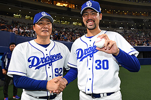 プロ初勝利を挙げウイニングボールを手に与田監督と握手を交わす阿知羅投手