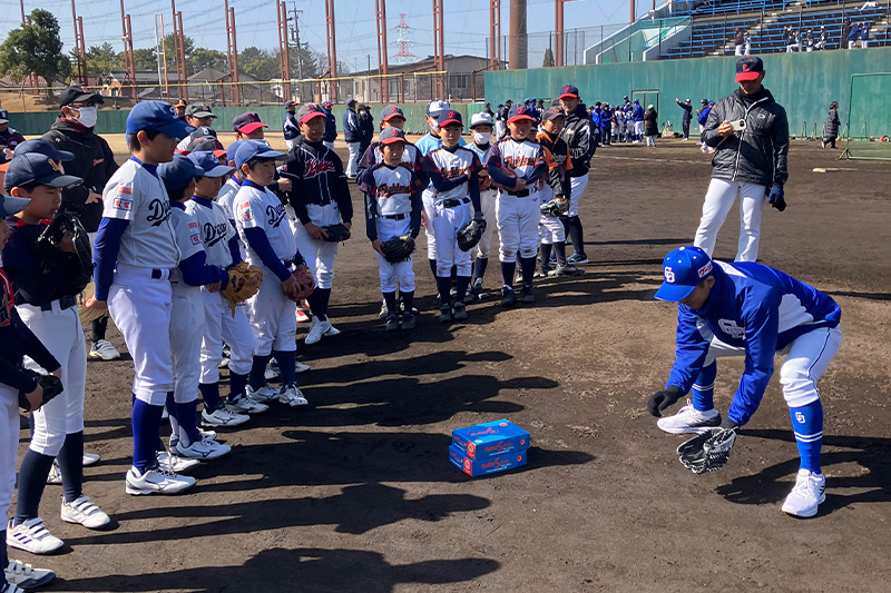 子供達にゴロの捕り方を教える湊川さん